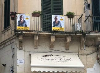 Manifesti di un candidato di Salvemini sul balcone di Piazza Sant’Oronzo, l’opposizione insorge