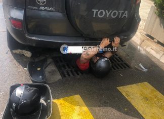 Centra un tombino con lo scooter, scivola sull’asfalto e si incastra sotto ad un suv